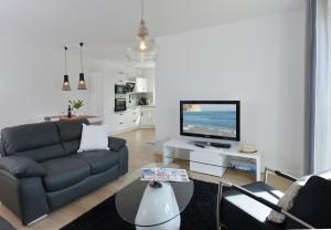 sala de estar con sofá y TV en Ferienwohnung Morgenrot, en Juliusruh