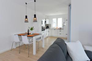 een keuken en een woonkamer met een tafel en een bank bij Ferienwohnung Morgenrot in Juliusruh