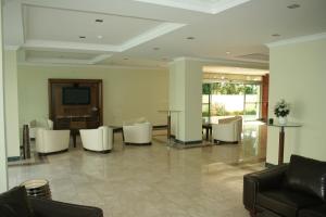 a lobby with white chairs and a table and a television at Alkan Hotel in Marmaris
