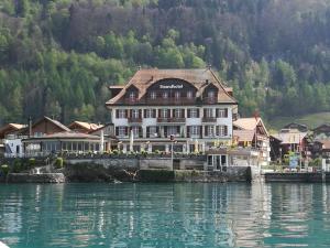 un grande edificio seduto sul lato di un corpo d'acqua di Hotel Strandhotel a Iseltwald