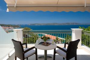 d'une table et de chaises blanches sur un balcon avec vue. dans l'établissement Hotel Anezina, à Pylos