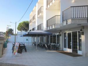 an outdoor patio with tables and chairs and an umbrella at Hotel Sixto in Montalvo