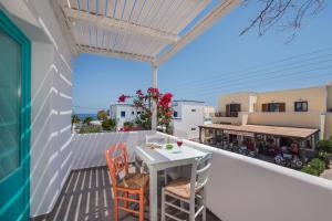 a white table and chairs on a balcony with a view at Nissia Beach Apartments & Suites in Kamari