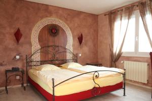 a bedroom with a bed with a wrought iron headboard at Hotel Restaurant Champ Alsace in Haguenau +27 photos