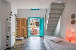 a bedroom with a staircase and a bed and a table at Nissia Beach Apartments & Suites in Kamari +37 photos