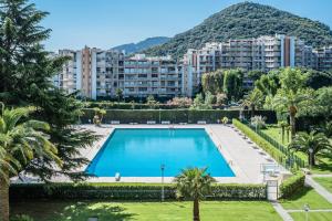 une grande piscine en face d'un grand bâtiment dans l'établissement Cannes Marina Appart Hotel Mandelieu, à Mandelieu-la-Napoule