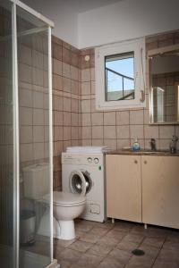 KalavárdaにあるBeach Villa Kalavardaのバスルーム(トイレ、洗面台付)、窓が備わります。