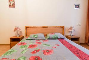 een slaapkamer met een bed met een bloemenbed en 2 lampen bij Apartment on Evreyskaya 42a in Odessa