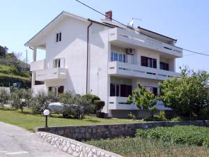 蘇佩塔斯卡德拉加的住宿－Apartments Rezek，前面有石墙的白色房子