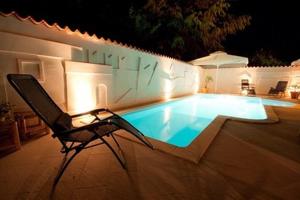 krzesło siedzące w nocy przy basenie w obiekcie Hotel Makin w mieście Novigrad