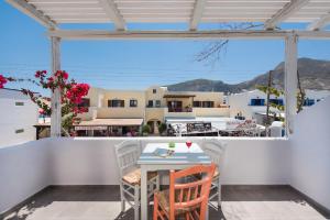 a table and chairs on a balcony with a view at Nissia Beach Apartments & Suites in Kamari