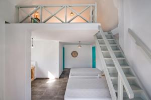 a room with two beds and a staircase at Nissia Beach Apartments & Suites in Kamari