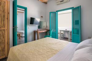 a bedroom with green doors and a desk and a bed at Nissia Beach Apartments & Suites in Kamari
