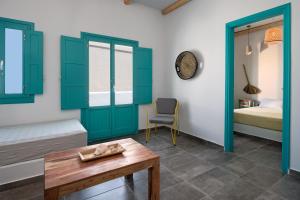 a room with green doors and a table and a bed at Nissia Beach Apartments & Suites in Kamari