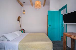 a bedroom with a bed and a blue door at Nissia Beach Apartments & Suites in Kamari