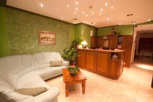 a living room with a white couch and a kitchen at Hotel Makin in Novigrad Istria