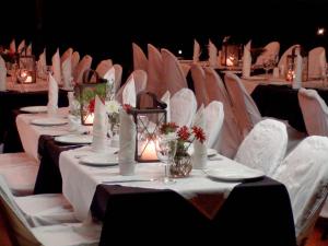 a banquet hall with white tables and white chairs at Polokwane Place in Polokwane
