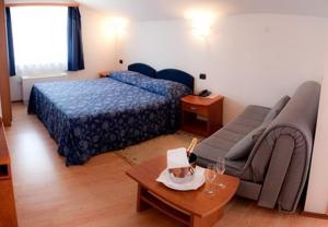 sypialnia z łóżkiem, kanapą i stołem w obiekcie Hotel Makin w mieście Novigrad