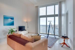 een woonkamer met een bank en een groot raam bij Marvellous Apartment in Tigne Point in Sliema