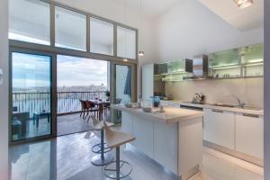 eine Küche mit einer Theke und Blick auf einen Balkon in der Unterkunft Marvellous Apartment in Tigne Point in Sliema