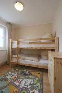 1 dormitorio con litera y alfombra en Landhäuser Bergwiese - Ferienhaus Höhenblick, en Sankt Andreasberg
