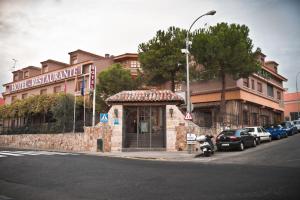 ein Gebäude an der Ecke einer Straße mit geparkt in der Unterkunft Hotel Algete in Algete