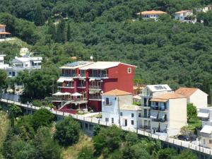 un groupe de maisons sur une colline plantée d'arbres dans l'établissement Palatino Hotel, à Parga