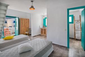 a bedroom with two beds and a desk at Nissia Beach Apartments & Suites in Kamari