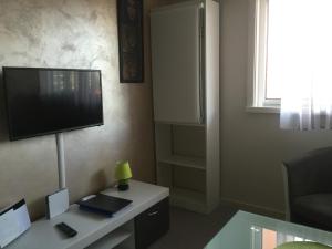 uma sala de estar com uma televisão e uma secretária com um candeeiro em Fréjus Studio em Fréjus