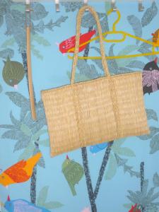 a wicker bag hanging on a wall with fishes at BZE Apartment in Budapest