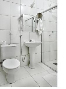 ein weißes Bad mit einem WC und einem Waschbecken in der Unterkunft Hotel Dan Inn Barretos in Barretos