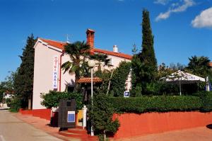 un edificio en una calle con árboles y arbustos en Hotel Makin, en Novigrad Istria