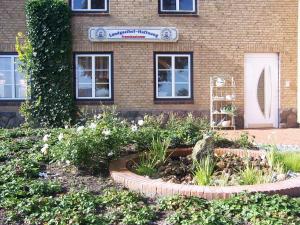 un edificio con un jardín de flores delante de él en Landgasthof Hoffnung en Handewitt