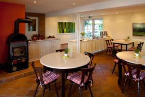 un restaurante con 2 mesas y estufa de leña en Landgasthof Hoffnung en Handewitt