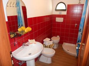 カステルヌオーヴォ・ディ・ポルトにあるGiro del Colleの赤いタイル張りのバスルーム(洗面台、トイレ付)