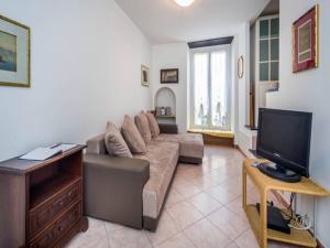 een woonkamer met een bank en een tv bij Garibaldi Flexyrent Apartment in Rapallo