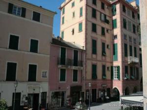 twee hoge gebouwen naast elkaar in een straat bij Garibaldi Flexyrent Apartment in Rapallo