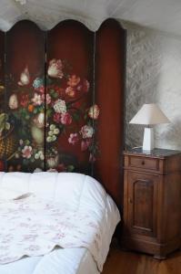 a bedroom with a painting of flowers on the wall at Petit appart in Montéléger