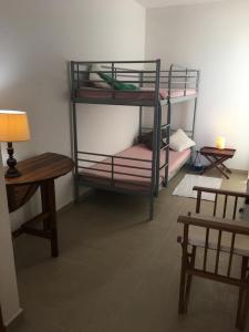 a room with two bunk beds and a table at Monte Gordo Flat in Monte Gordo