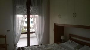 マルティンシクーロにあるAppartamento Capriのベッドルーム1室(ベッド1台、大きな窓付)