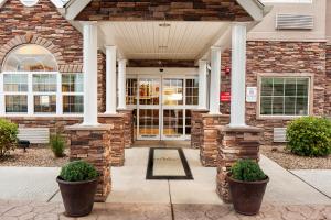 a brick house with a front door with pillars at Microtel Inn & Suites by Wyndham Wheeling at The Highlands in Triadelphia