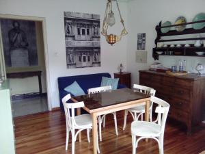 une table de salle à manger avec des chaises blanches et un canapé bleu dans l'établissement Da Nerina, à Cormòns