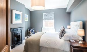 a blue bedroom with a bed and a fireplace at Lobster Cottage Lytham in Lytham St Annes
