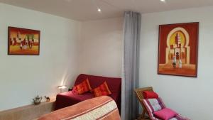 uma sala de estar com um sofá vermelho e uma cadeira em Chambre Avec Jardin Pierre Curie em Bry-sur-Marne