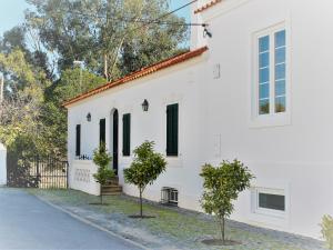 uma casa branca com duas árvores em frente em Casas da Estação em Marvão