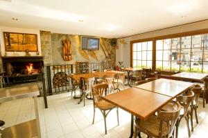 a restaurant with tables and chairs and a fireplace at Hotel Llibrada in Benasque