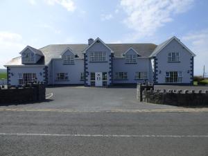 een groot wit huis met een grote oprit bij Atlantic View House in Doolin