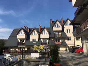 a large white building with black roof at Apartamenty Skaldowie in Zakopane