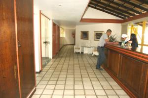 a man standing at a counter in a kitchen at Total vista mar Gamboa de Cima in Salvador