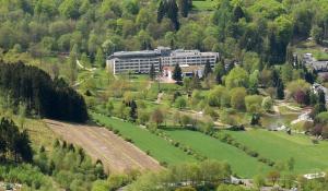 ein großes Gebäude mitten auf einem grünen Feld in der Unterkunft Hotel Am Kurpark in Brilon